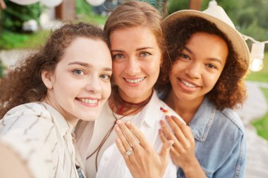Güzel genç bir kadının pov portresi. Nişan yüzüğünü gösteriyor. Arkadaşlarıyla dışarıda parti yaparken selfie çekiyor.