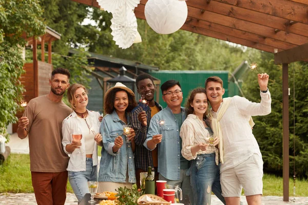 Multietnisk Grupp Ungdomar Som Håller Tomtebloss Och Ler Mot Kameran — Stockfoto