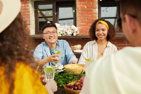 Çok ırklı bir arkadaş grubu açık terasta oturup, uzayın fotokopisini çekerken dışarıda akşam yemeğinin tadını çıkarıyor.