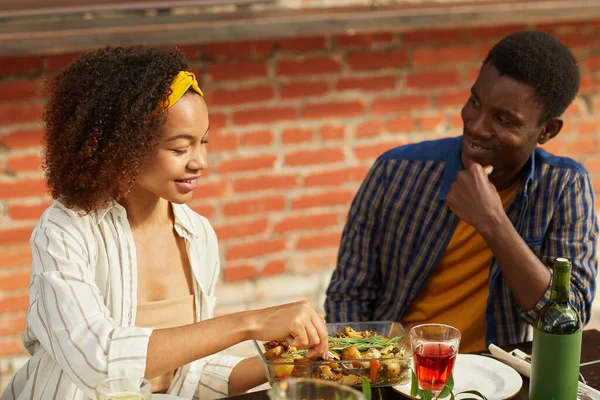 在夏季派对上 年轻的非洲裔美国男人一边在户外与朋友一起享受晚餐 一边看着美丽的女人的画像 复制空间 — 图库照片
