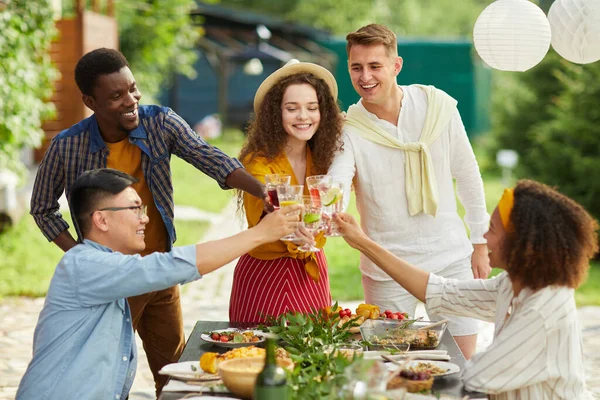 Grupo Multiétnico Amigos Tintineando Vasos Mientras Disfrutan Cena Aire Libre —  Fotos de Stock