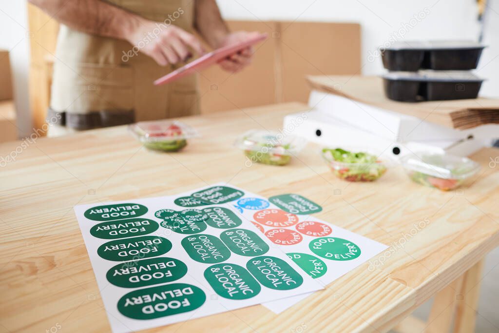 Close up of unrecognizable worker sticking labels and packaging orders in food delivery service, copy space