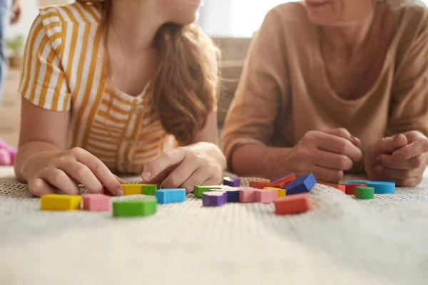 Warm Toned Close Unrecognizable Girl Playing Colorful Blocks While Lying — Stock Photo, Image