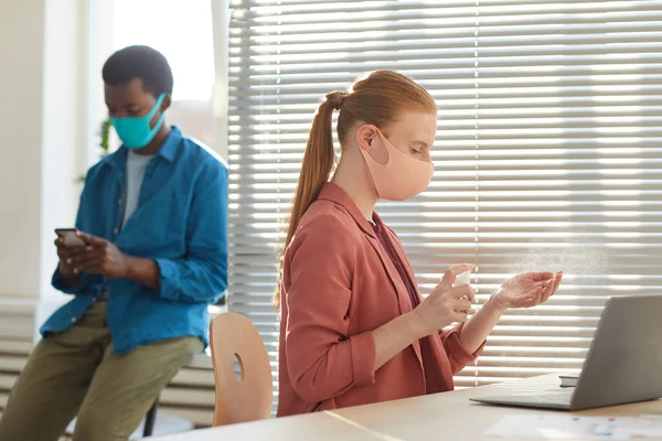 Sidovy Porträtt Ung Kvinna Bär Ansiktsmask Sanera Händer Arbetsplatsen Efter — Stockfoto