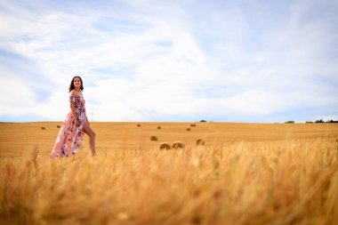 Genç kadın bir anız alan yürüyor.