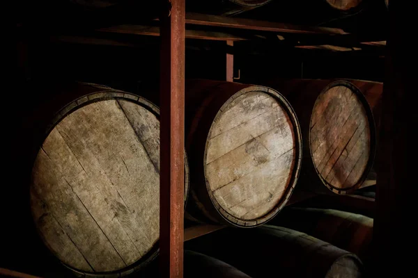 Rum or whiskey wooden barrels stacked in a warehouse