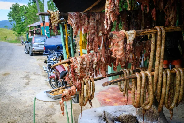 Original Caribbean food on the roadside in the Dominican Republic. Smoked pork, morcillas and longanizas