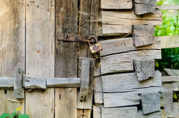 Porta de madeira autêntica e uma fechadura vintage em um loop enferrujado, conceito de objetos antigos — Fotografia de Stock
