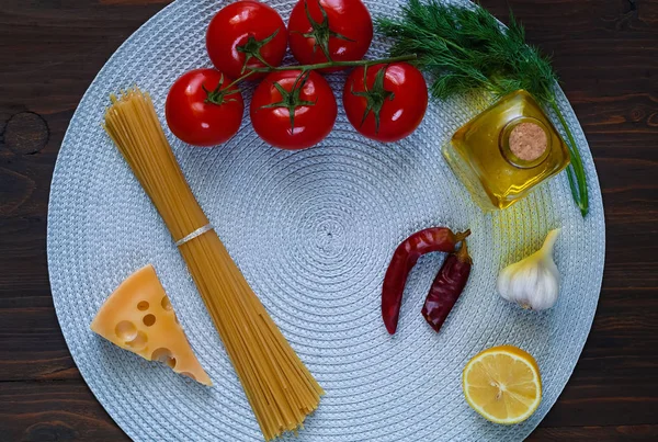 Ingrediënten voor het koken van pasta op blauwe ronde servet op houten achtergrond. Concept van de Italiaanse keuken, kopie ruimte, close-up. — Stockfoto