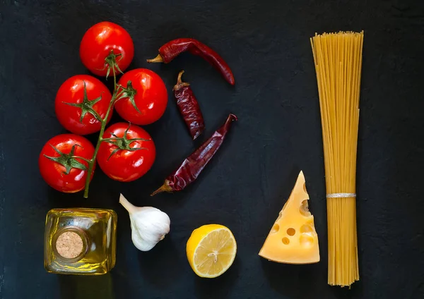 Ingrediënten voor het koken van pasta op donkere achtergrond. Frame van biologisch voedsel. Het concept van vegetarisch voedsel en gezonde voeding, — Stockfoto