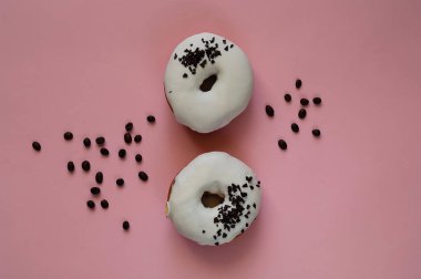 Donuts bir pembe bir arka plan, kavramı renkli kahvaltı, kopya alanı üzerine beyaz krema ile, 