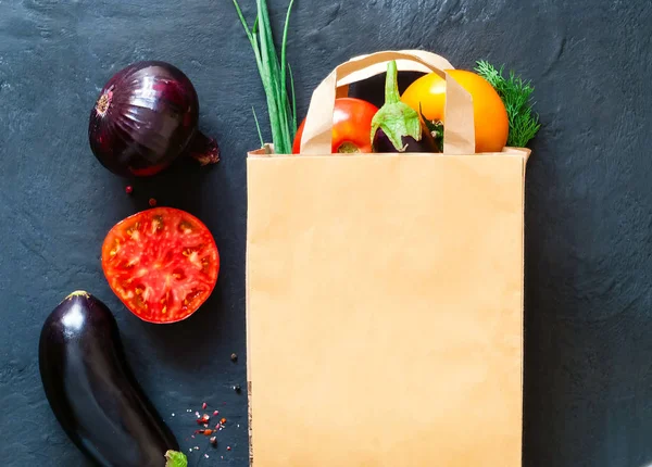 traditional vegetables in paper bag on dark background, shopping in supermarket, concept of healthy diet, copy space, closeup
