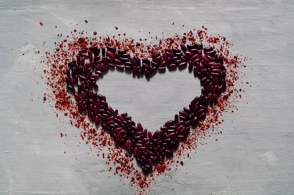 Food background of beans and chili peppers in the shape of heart,top view,copy space, closeup. Diet, pure food or the concept of vegetarian food.