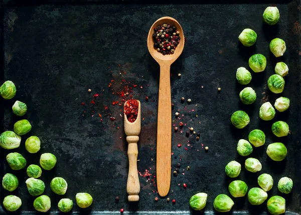 wooden spoon with spices and fresh brussels sprouts  on vintage rusty metal background, vegetables for healthy cooking, flat lay,copy space, closeup. Diet, pure food or the concept of vegetarian food