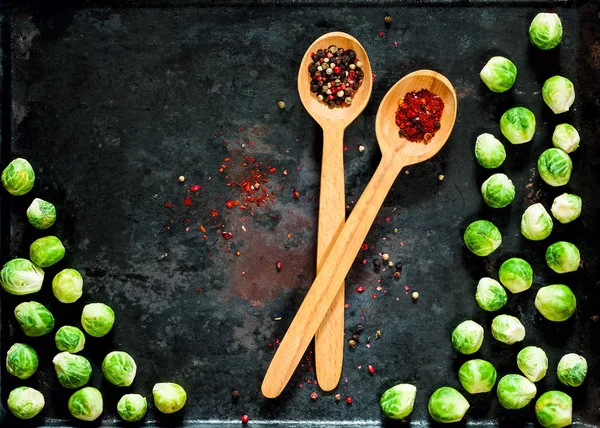 wooden spoon with spices and fresh brussels sprouts  on vintage rusty metal background, vegetables for healthy cooking, flat lay,copy space, closeup. Diet, pure food or the concept of vegetarian food