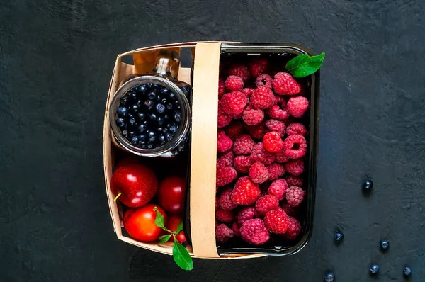 Koyu arka plan üzerinde organik çilek sepetle. Çilek, kopya alanı, portre, baner hasat