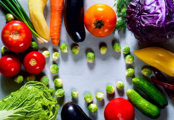 briussel cabbage in the shape of heart and fresh vegetables for healthy cooking on light wooden background, flat lay, copy space, closeup. Diet, pure food or the concept of vegetarian food.