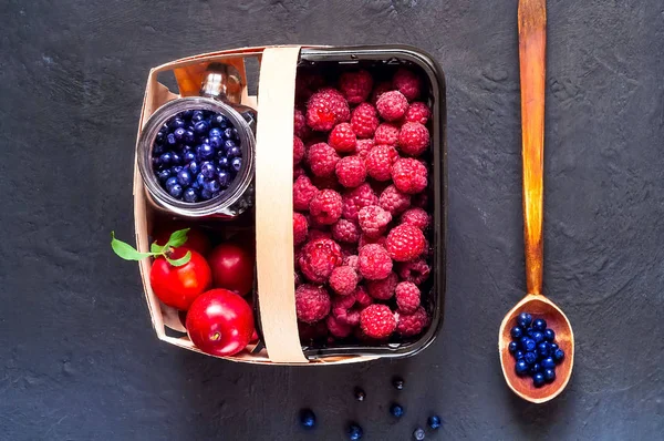 tahta kaşık ve koyu arka plan üzerinde organik çilek sepetle. Çilek, kopya alanı, portre, baner hasat