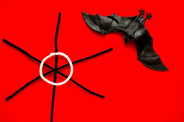 Símbolo de HALLOWEEN es tela de araña de murciélago y negro sobre fondo rojo, espacio de copia, primer plano , — Foto de Stock