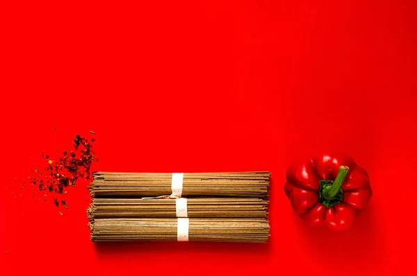 Tradizionale giapponese soba tagliatelle e ingredienti su sfondo rosso creativo, concetto di cibo asiatico e dieta sana, spazio copia, primo piano — Foto Stock
