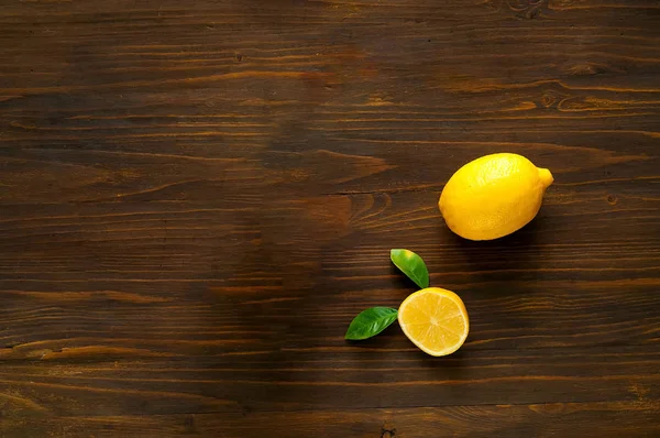 Citroner på mörka träbord. Platt låg. Ovanifrån, kopia utrymme, närbild. Kreativa banner av citron och blad. Matkoncept. — Stockfoto