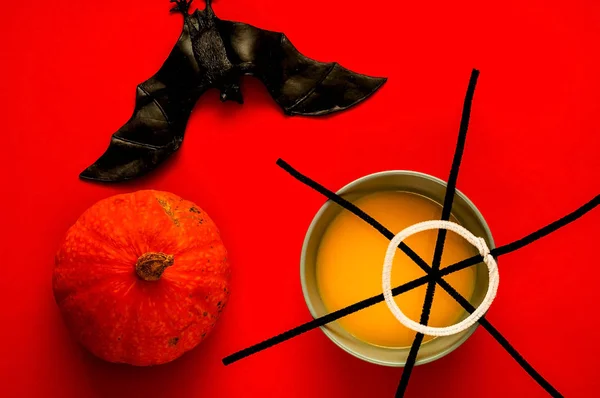 Zuppa di zucca in ciotola blu isolata su sfondo giallo, vista dall'alto. Simbolo di HALLOWEEN è ragnatela nera e pipistrello, spazio copia, primo piano , — Foto Stock