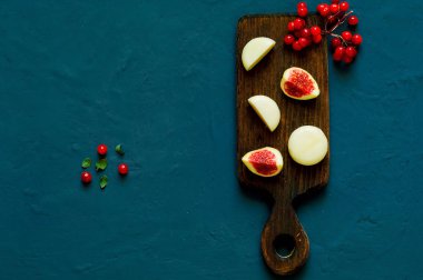 incir ve beton koyu arka plan üzerinde ahşap tahta üzerinde keçi peyniri. Sağlıklı beslenme kavramı, portre, kopya alanı