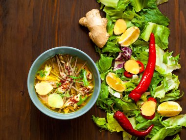 Çorba Buckwheat Noodles Soba ve somon salata yaprakları gelen organik doku üzerinde mavi kase, Ahşap Background.Top görünüm Chili biber ile Asya tarzı ışık, uzay kopyalayın, yat.
