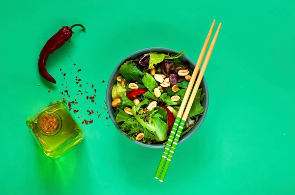 Salade thaïlandaise épicée au boeuf et aux noix dans un bol bleu avec baguettes sur fond vert clair, concept d'aliments biologiques, aliments de désintoxication ou concept végétarien. . — Photo