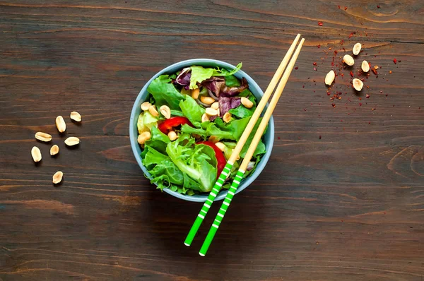 Lachssalat in blauer Schüssel mit Stäbchen auf hölzernem Hintergrund, Bio-Ernährungskonzept, Detox-Food oder vegetarisches Konzept. Ansicht von oben, Kopierfläche, flache Lage. — Stockfoto