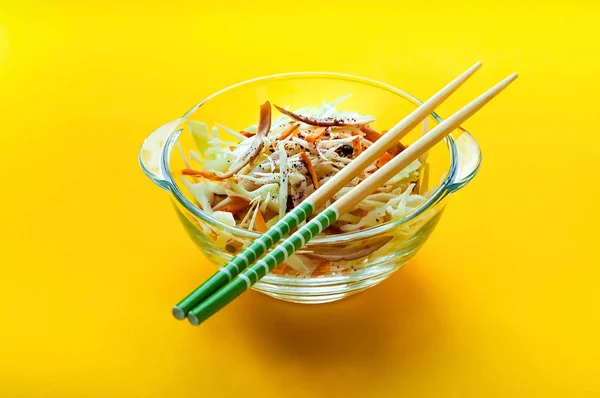 Salade de chou salade Coleslaw dans un bol en verre avec des baguettes sur fond jaune, isolé, concept d'aliments biologiques, aliments de désintoxication ou concept végétarien. . — Photo