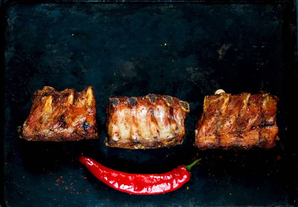 Costolette di ricambio piccanti alla griglia calde di BBQ servite con peperoncino caldo su sfondo metallico arrugginito vintage. Vista dall'alto, copiare lo spazio, lay flat . — Foto Stock