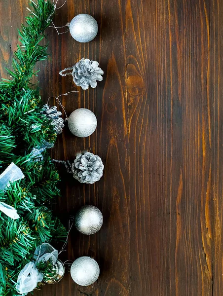 Рождественский декор. Декоративная елка с серебристым декором и праздничными блестящими серебряными шариками на деревянном фоне, вертикально — стоковое фото