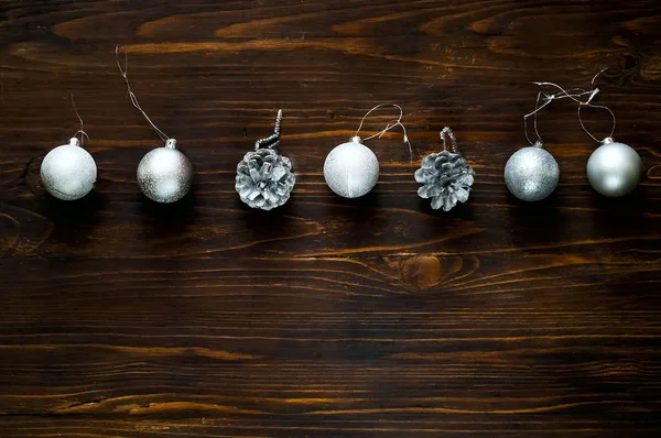 Decoración de Navidad. bolas y conos de plata sobre fondo de madera, concepto de vacaciones de Año Nuevo, primer plano —  Fotos de Stock