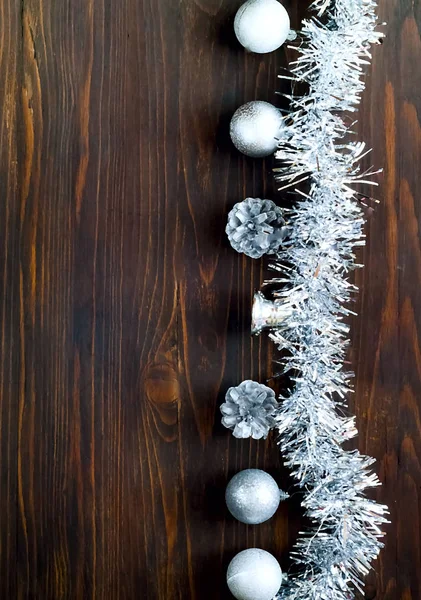 Decoración de Navidad. bolas y conos de plata sobre fondo de madera, concepto de vacaciones de Año Nuevo, primer plano, espacio de copia, vertical —  Fotos de Stock