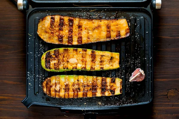 Zucchine piccanti alla griglia e melanzane calde, cotte su una griglia elettrica. Bandiera. Il concetto di alimentazione sana e cibo delizioso . — Foto Stock