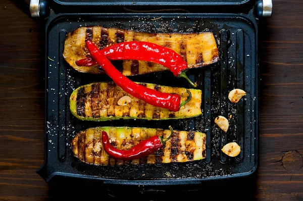 Zucchine piccanti alla griglia e melanzane calde, cotte su una griglia elettrica. Bandiera. Il concetto di alimentazione sana e cibo delizioso . — Foto Stock