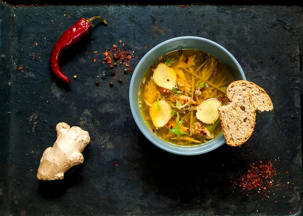 Light Soup in Asian Style with Buckwheat Noodles Soba and Salmon on black old metal background.Top view, copy space, flat lay.