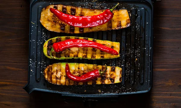 Zucchine piccanti alla griglia e melanzane calde, cotte su una griglia elettrica. Bandiera. Il concetto di mangiare sano e cibo buono.Vista dall'alto, spazio copia, posa piatta, primo piano — Foto Stock