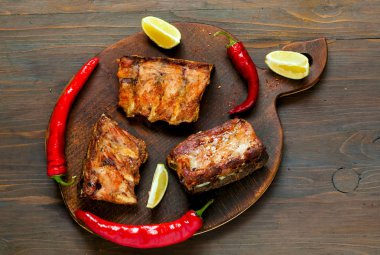 Baharatlı sıcak ızgara yedek kaburga Barbekü gelen sıcak biber ve koyu ahşap zemin üzerine kireç ile devam eder. Afiş. Görünümü ana sayfa, yer kopyalayın, yat.