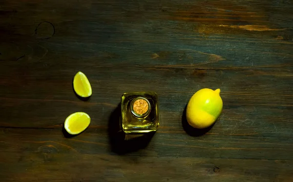 Aceite de limón en una botella de vidrio sobre un fondo de madera, de cerca —  Fotos de Stock