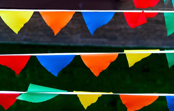 Colored flags in the shape of a triangle develop in the wind, close, copy space