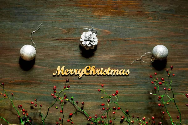 Composition du cadre de Noël ou du nouvel an avec bijoux en argent et baies rouges sur fond en bois. Concept de vacances et de célébration pour carte postale ou invitation. Couché à plat, vue de dessus. Espace de copie — Photo