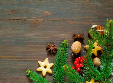 Ahşap figürler ve köknar ahşap arka plan ağaç dalları ile Noel ve yeni yıl çerçeve kompozisyon. Tatil ve kutlama kavramı kartpostal veya davet için. Düz yatıyordu, en iyi görünüm. Kopya alanı