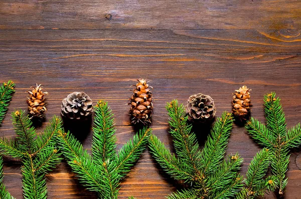 圣诞节或新年框架组成与冷杉树枝和红色浆果在木背景。节日和庆祝概念的明信片或邀请。平坦的平面, 顶部视图。复制空间 — 图库照片