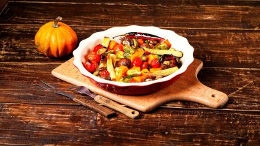 Ahşap arka plan üzerinde seramik kase bir ızgarada pişmiş baharatlı sıcak sebze. Sağlıklı beslenme ve leziz yemekleri kavramı. Üstten görünüm, kopya alanı, portre