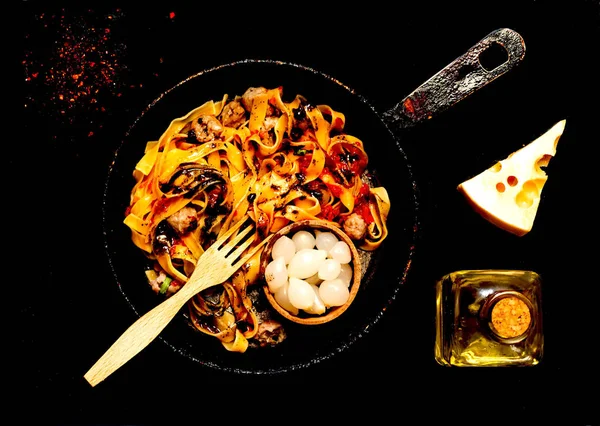 Italian pasta with meatballs and pickled onions in authentic pan on dark background. Concept of popular american spaghetti. Top view, close up, copy space. — Stock Photo, Image