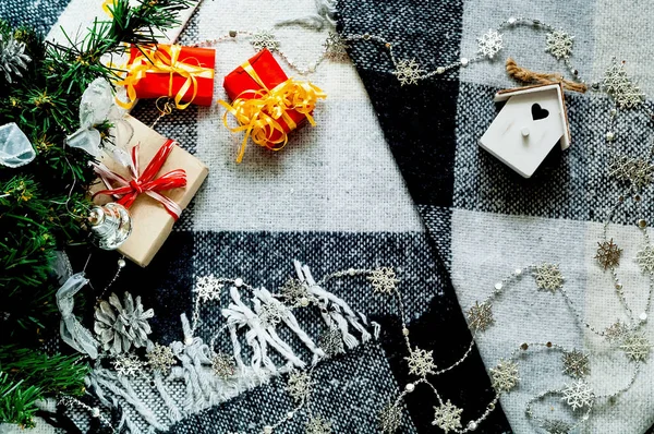 Праздничный фон с рождественскими украшениями и подарочными коробками на клетчатой клетке. Hygge Style, concept of New Year comfort — стоковое фото
