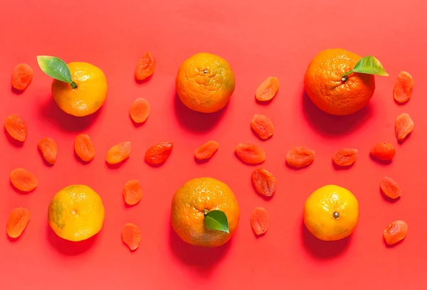 Mönster av mandariner och torkade aprikoser på bakgrunden av levande koraller. Färg av begreppet år 2019. Platt låg. Kopiera utrymme. — Stockfoto