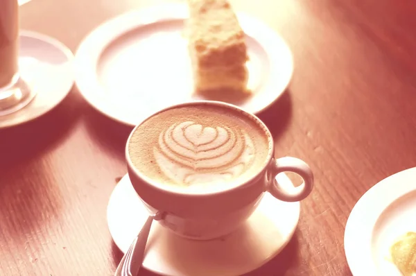 Kaffe i keramiska kopp med vackra skum på korall bakgrund. Begreppet frukost. Färg av begreppet år 2019. — Stockfoto